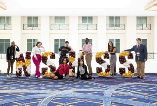 A group of students standing next to 樱花直播 Balloon letters